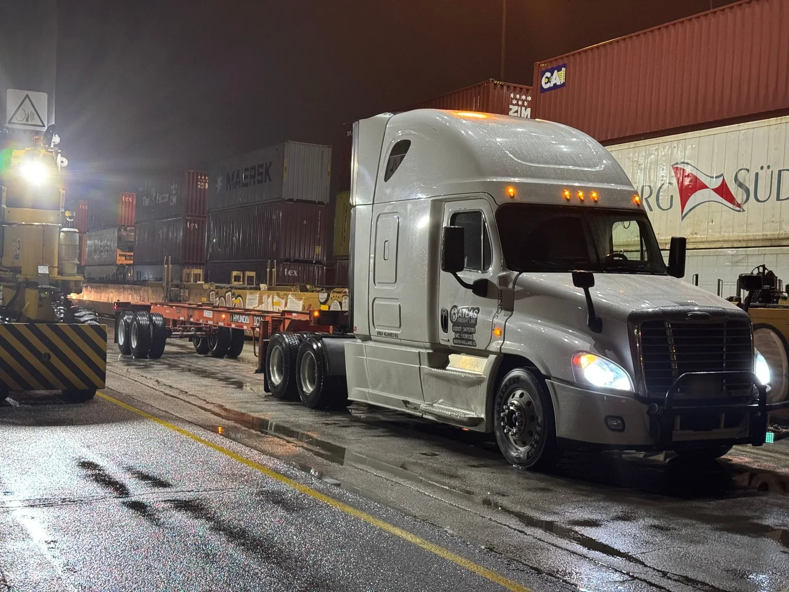 Atlas Freight Line Freightliner Cascadia hooked to a container chassis at night